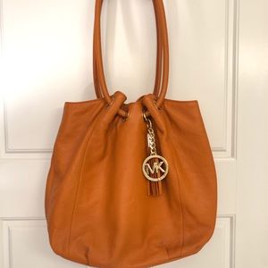 Michael Kors orange tassel bucket bag.